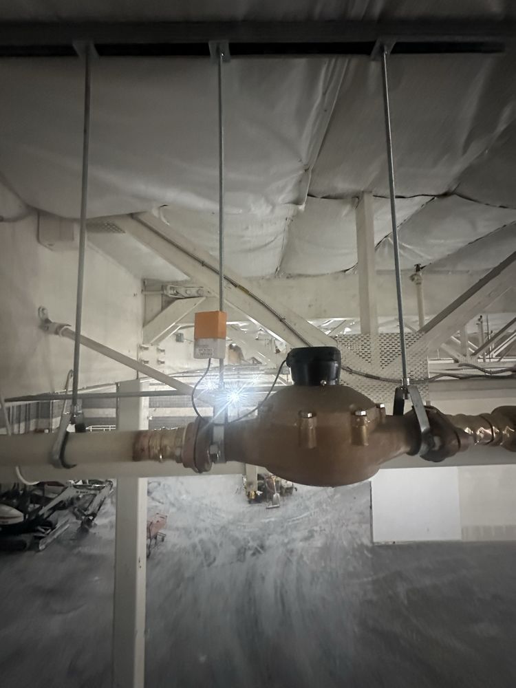 Commercial water meter assembly with backflow prevention device installed on overhead piping